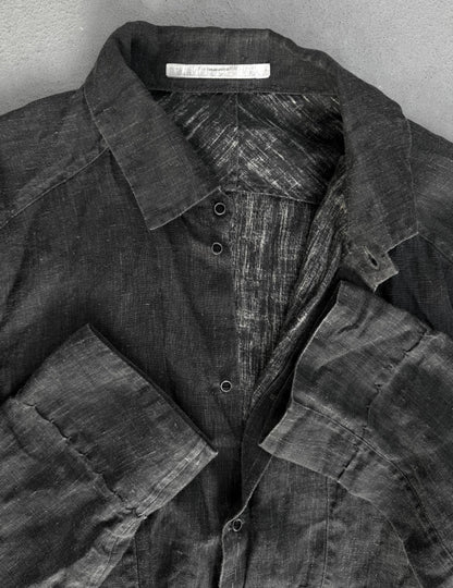 Dark denim shirt with a visible brand label on a gray background