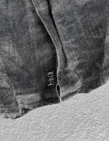 Close-up of a textured fabric with a brand logo on a light background