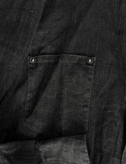 Close-up of a dark fabric pocket with buttons on a black background