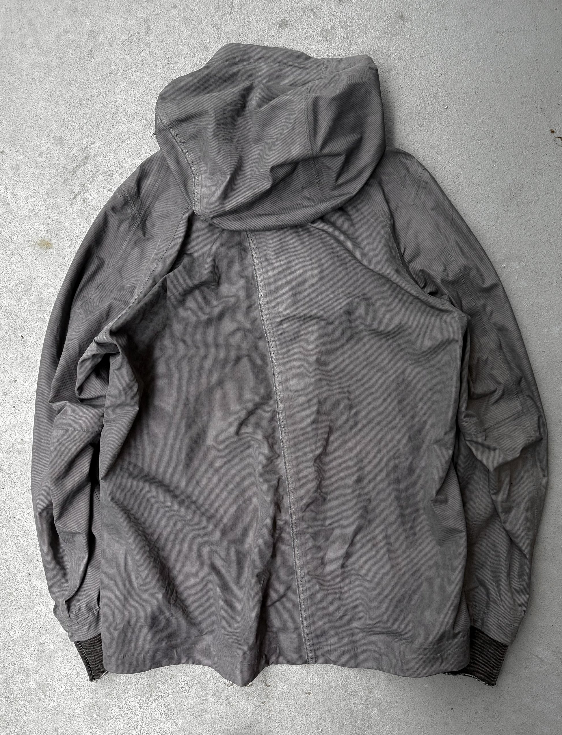 Gray hooded jacket on a textured gray surface