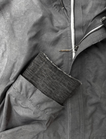 Close-up of a gray jacket with a zipper and patch detail