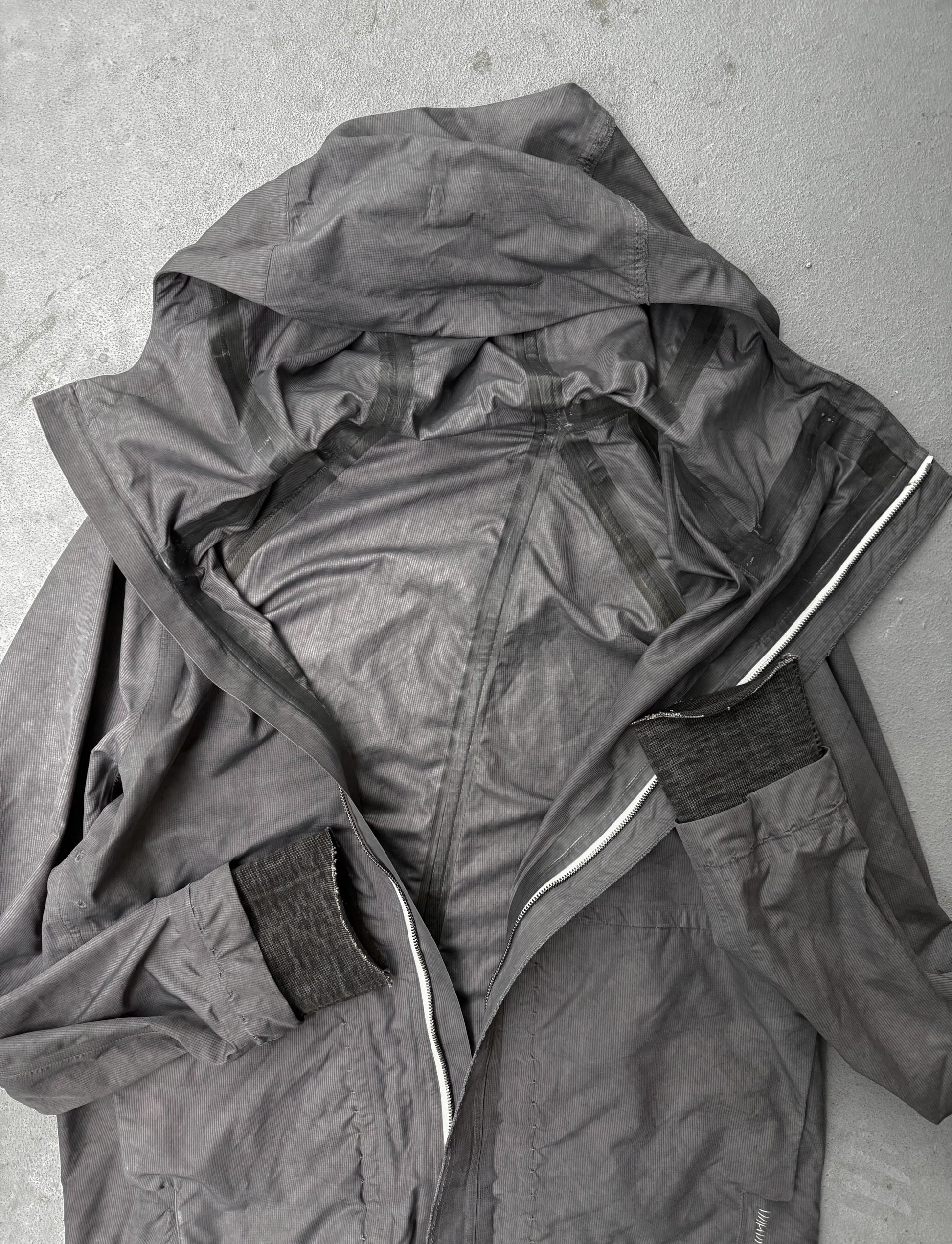 Dark gray raincoat with a hood on a light gray background