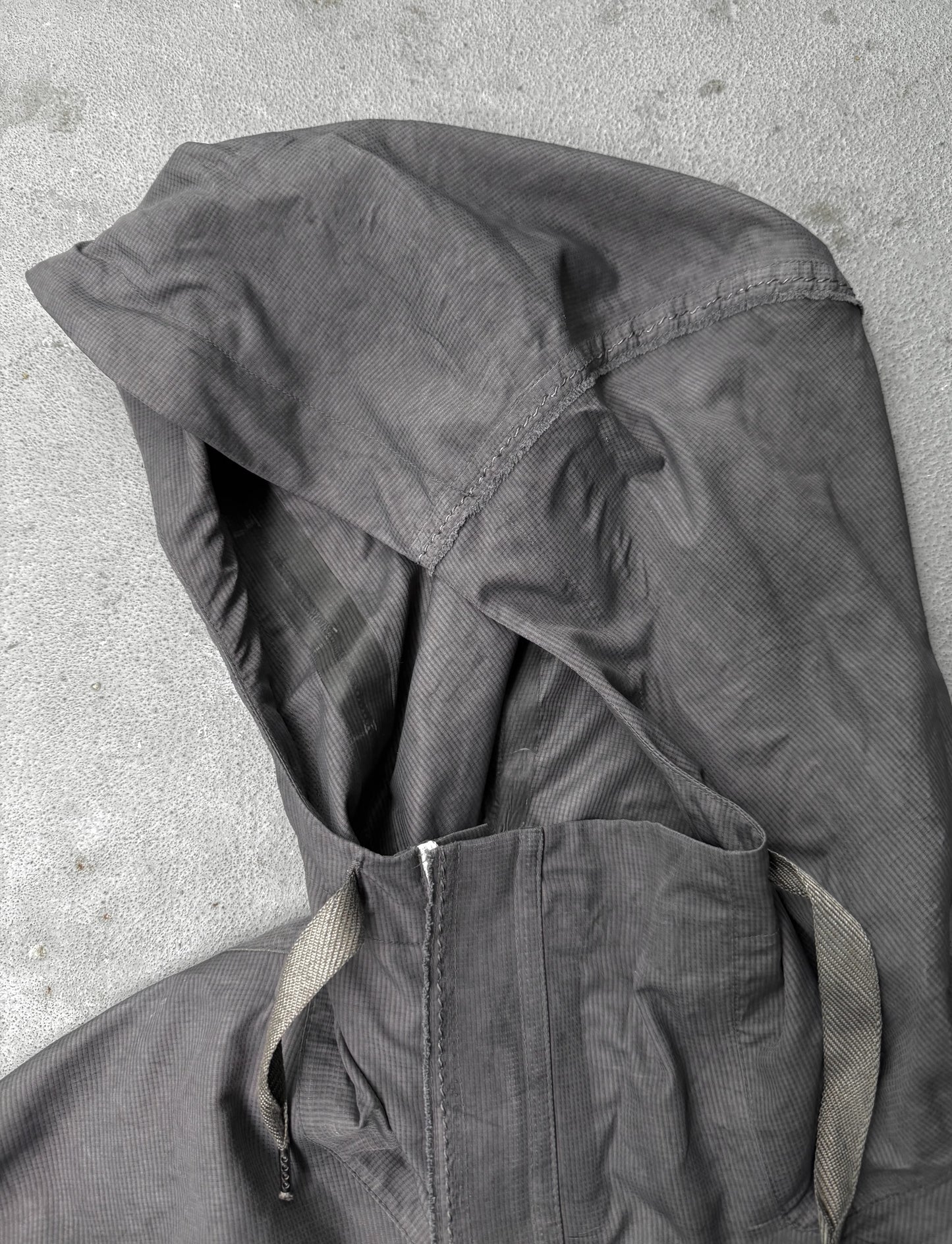 Dark gray jacket with hood on a light gray background
