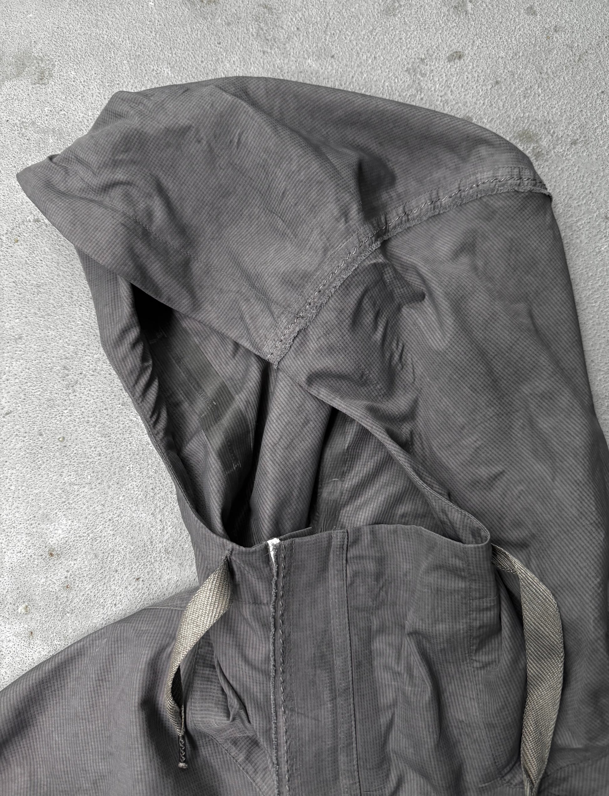 Dark gray jacket with hood on a light gray background