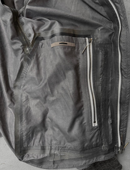 Close-up of a gray jacket with zippers and buttons on a neutral background