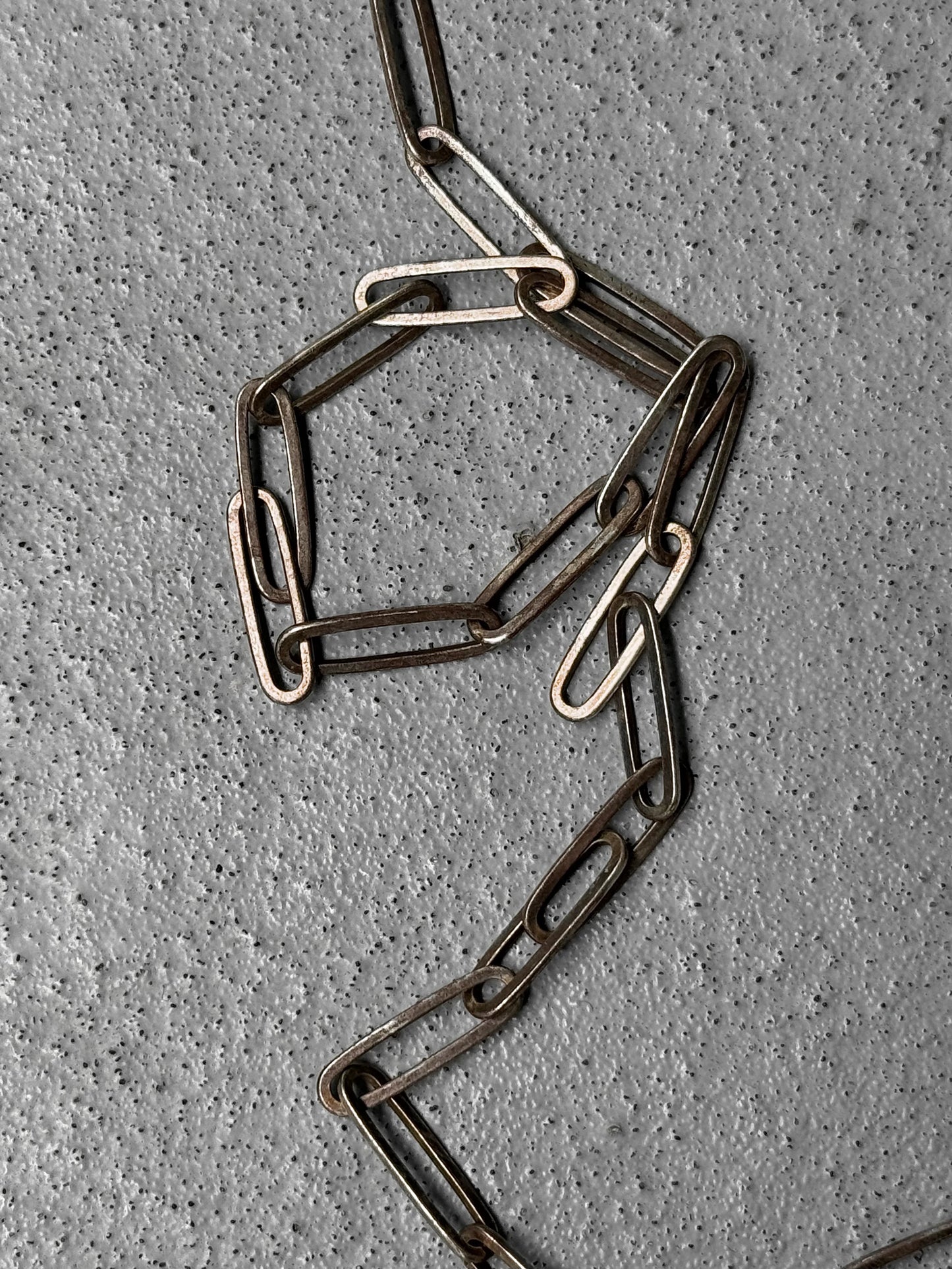 Metal chain on a textured gray surface