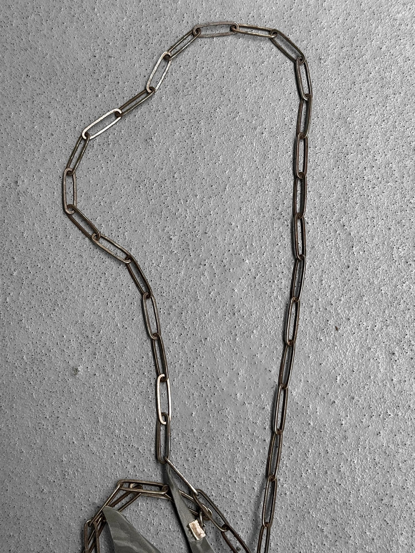 Metal chain on a textured gray surface