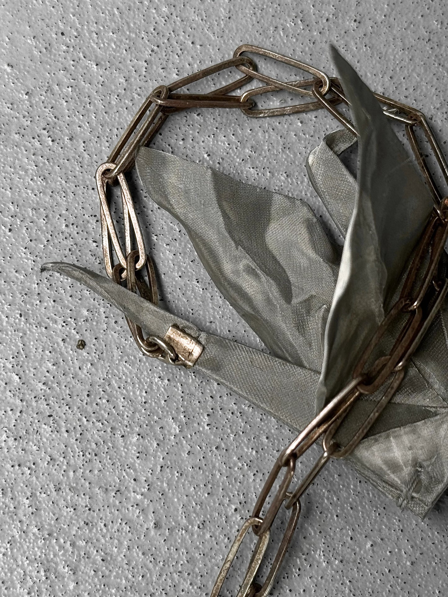 Gold chain necklace on a green fabric background