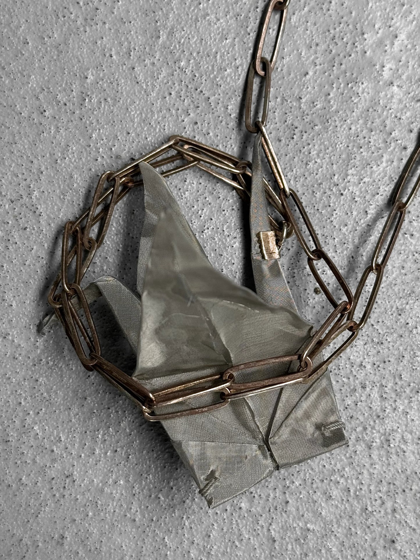 Necklace with geometric pendant on a textured surface