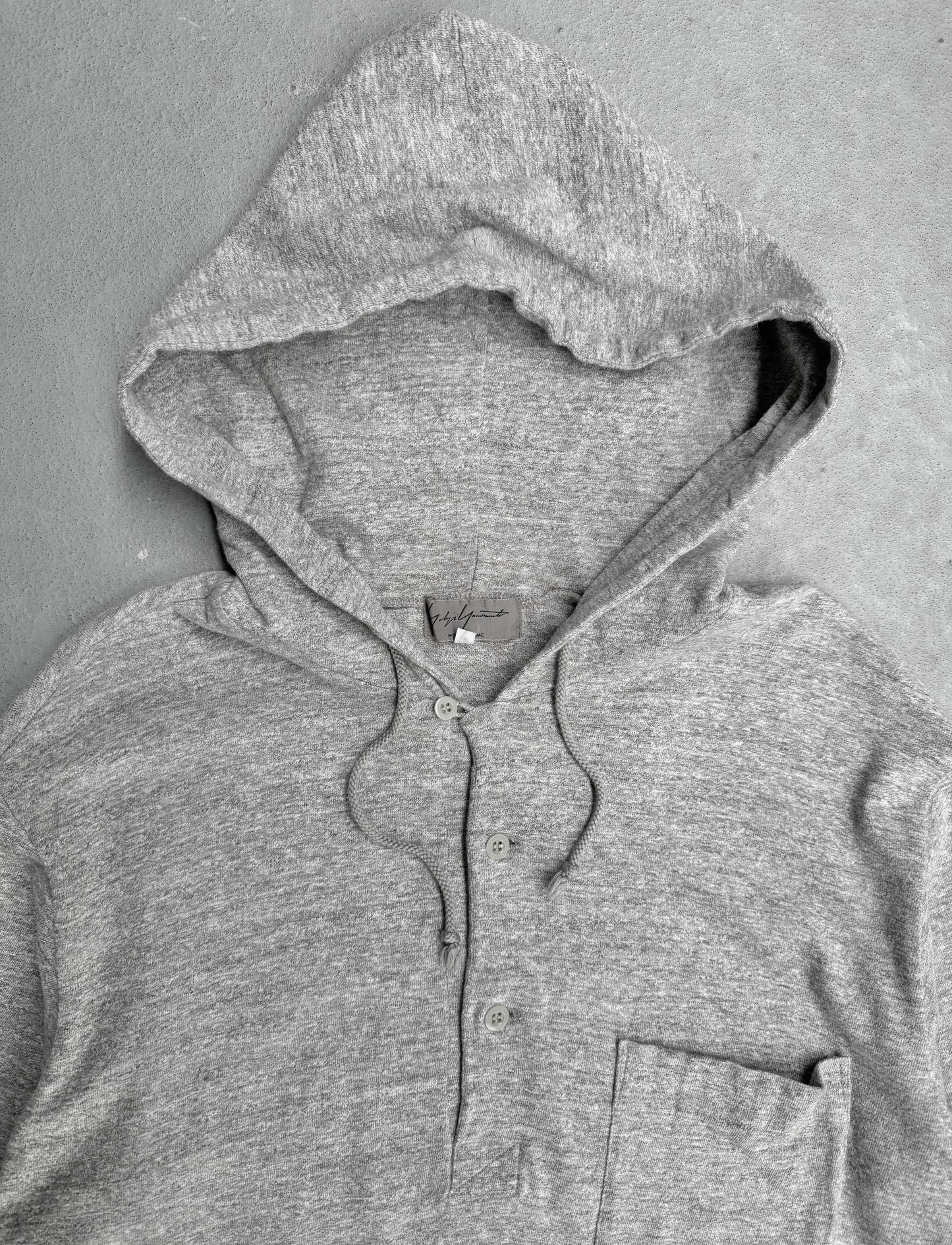 Gray hoodie with a brand label on a gray background
