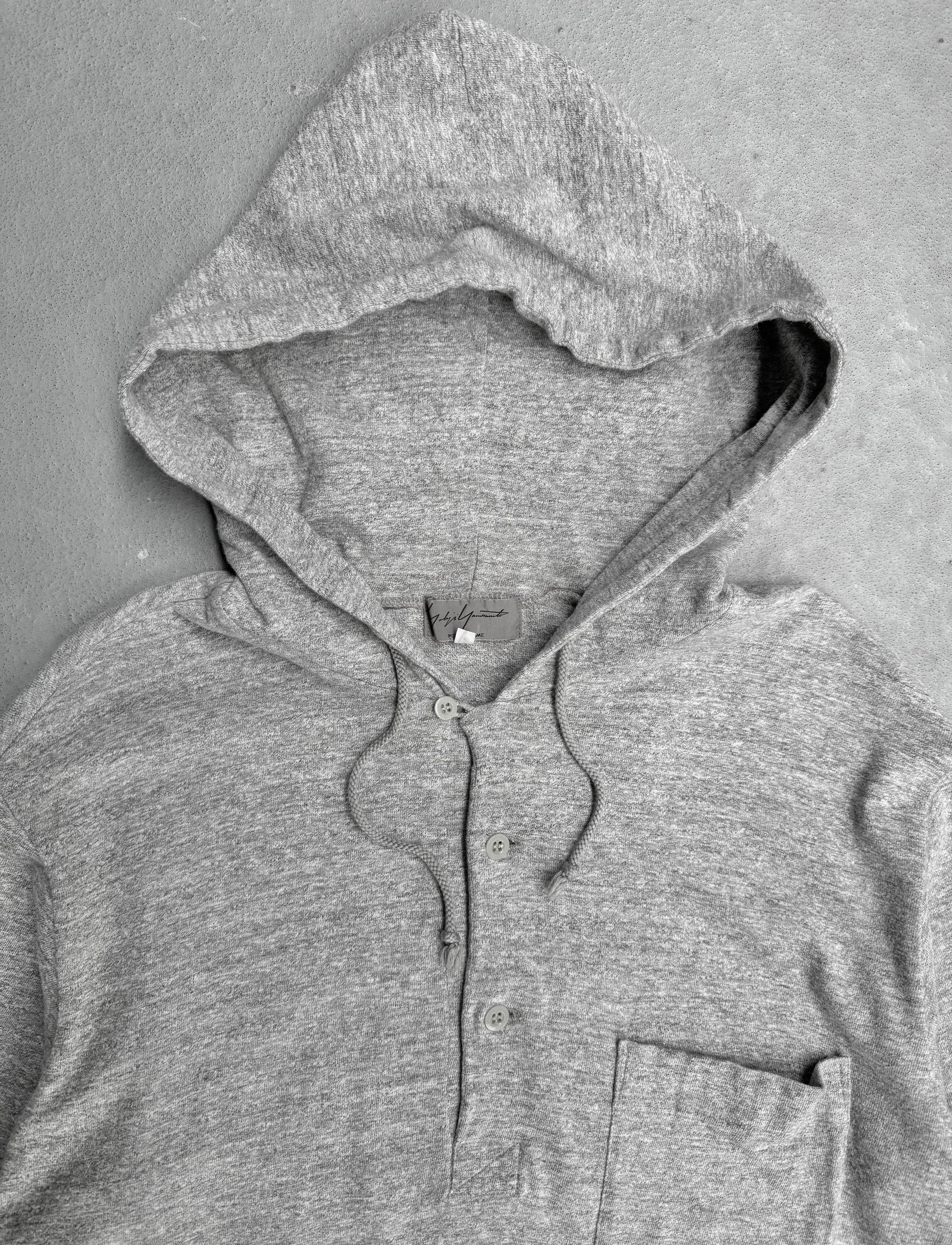 Gray hoodie with a brand label on a gray background