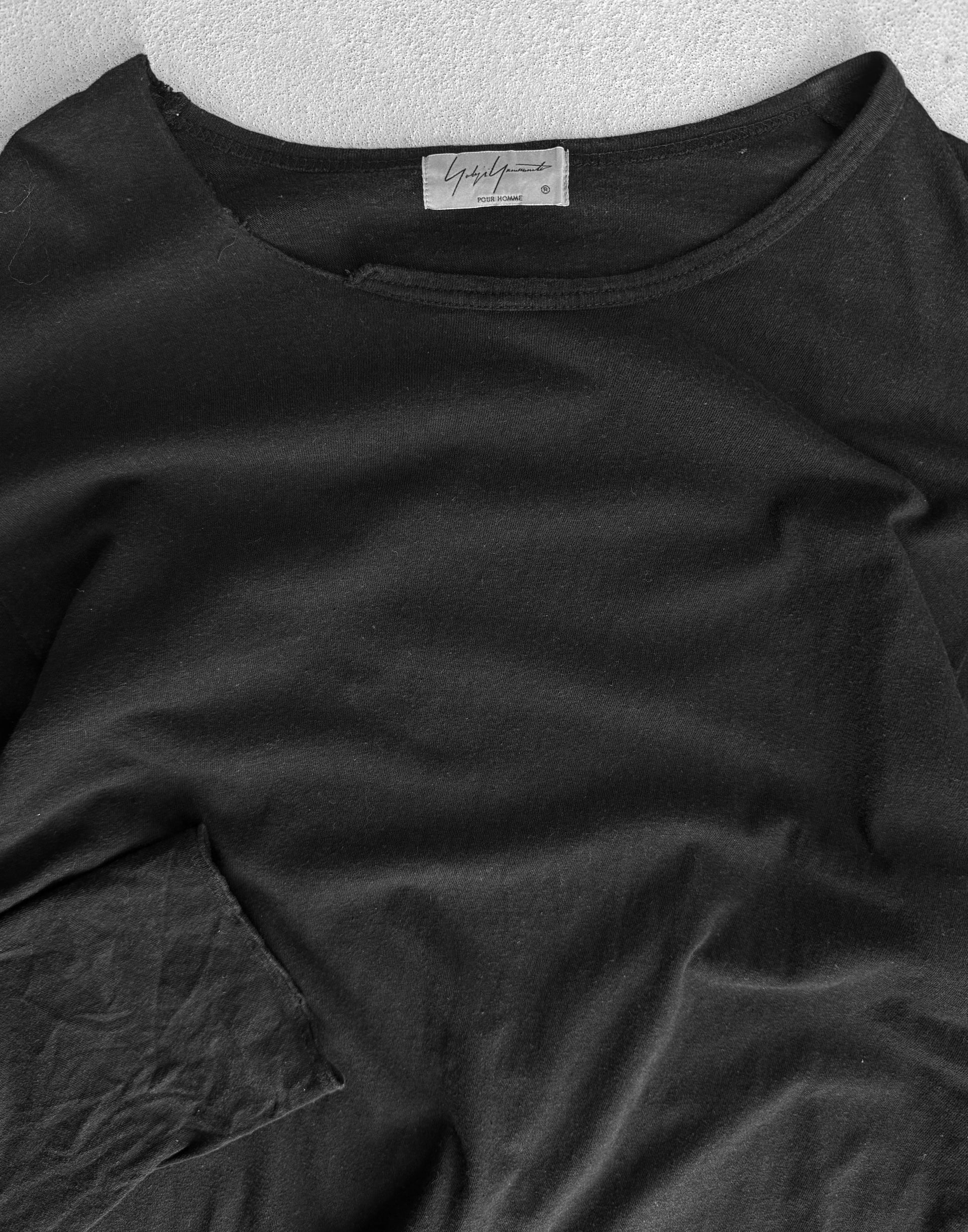 Black shirt with a brand label on a textured surface