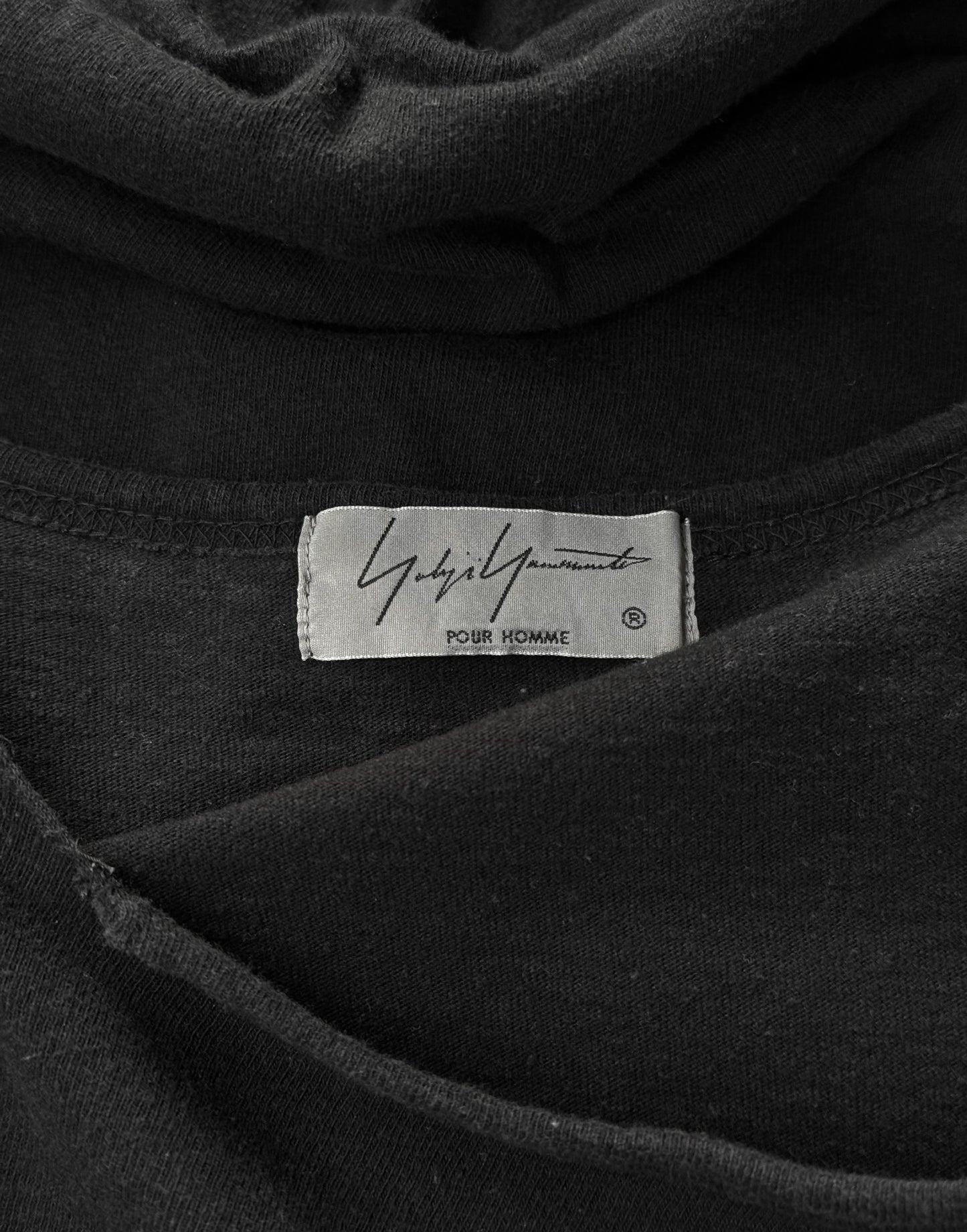 Close-up of a black garment with a label on a dark background