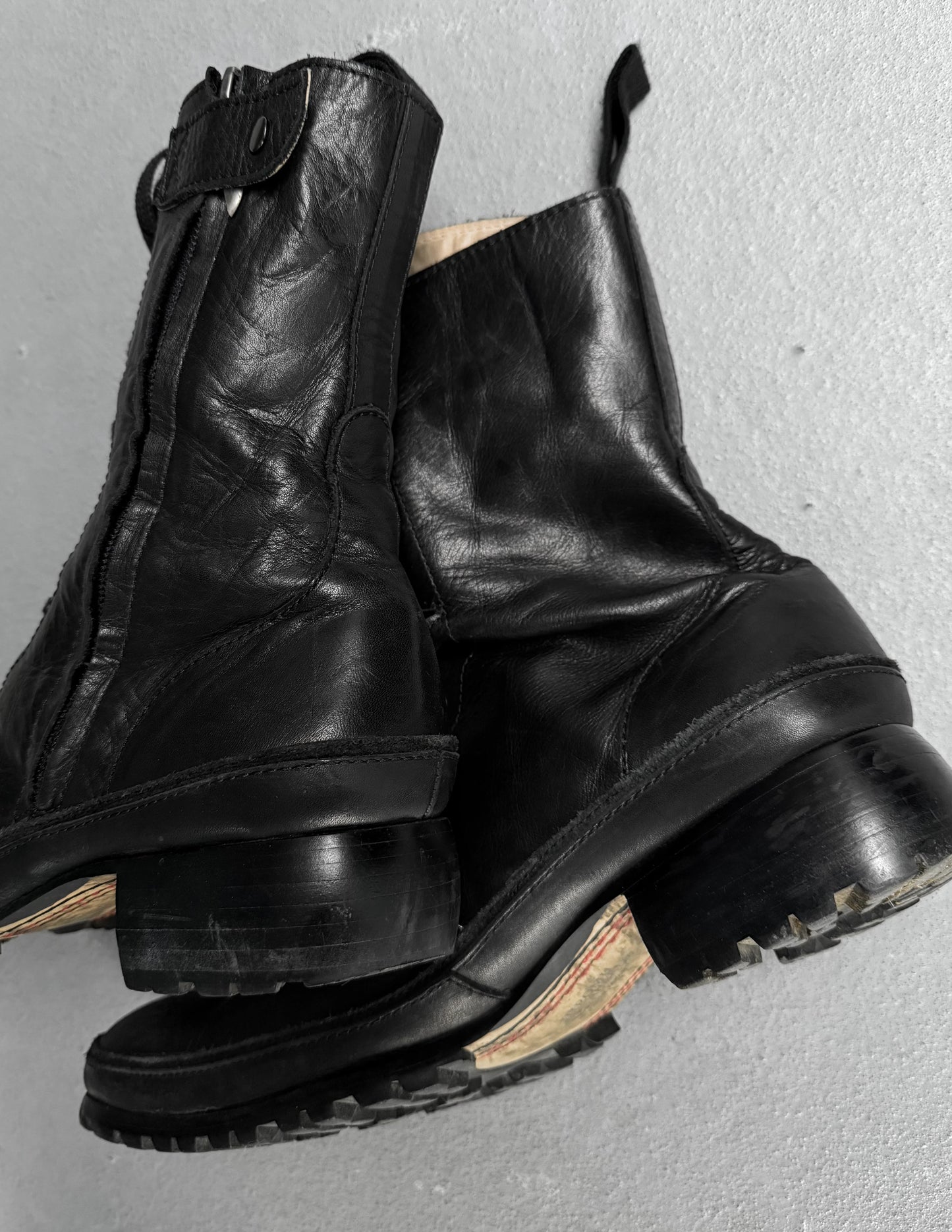 Pair of black leather boots on a gray background