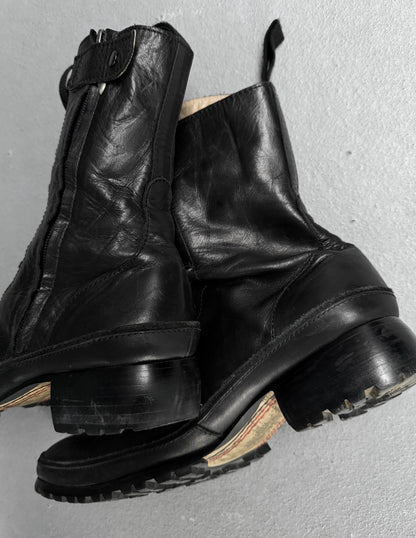 Pair of black leather boots on a gray background