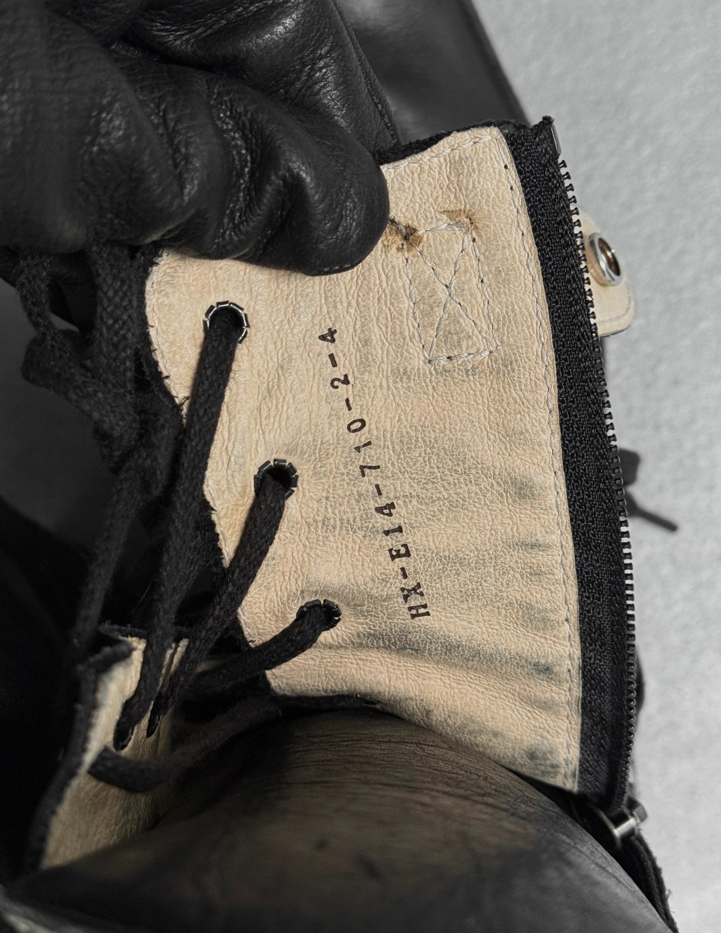 Close-up of a worn leather boot with a visible brand label.