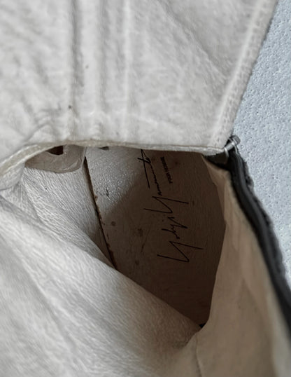 Close-up of a textured surface with a small cardboard piece and writing.