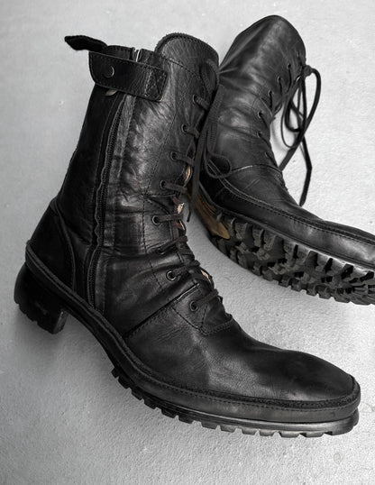 Pair of black leather boots on a light gray background