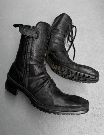 Pair of black leather boots on a gray background