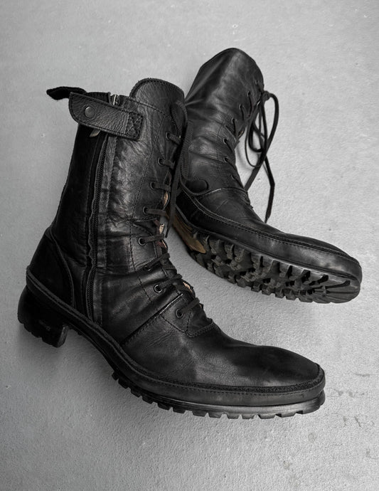 Pair of black leather boots on a gray background