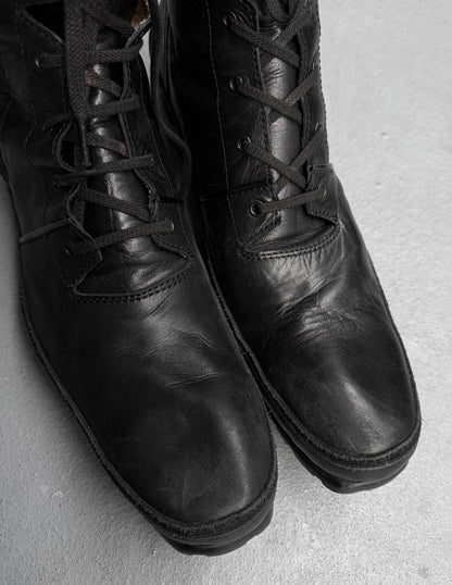 Pair of black leather boots on a light gray background