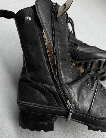 Close-up of black leather boots with zippers on a light gray background